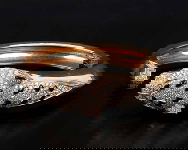 "Panthère de Cartier" - A luxurious gold bracelet adorned with diamonds, emeralds, and onyx stones.