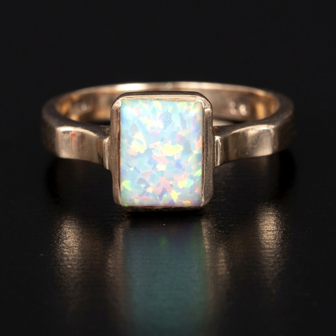 14K Yellow Gold and White Opal Ring: solitaire design containing one rectangular cabochon cut white opal measuring 8.0 x 6.5 mm. Stamp: 14K 0.3 Weight: 3.15 grams Ring Size: 6.5