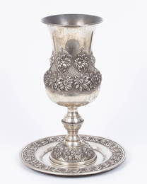 A huge silver goblet with a matching plate