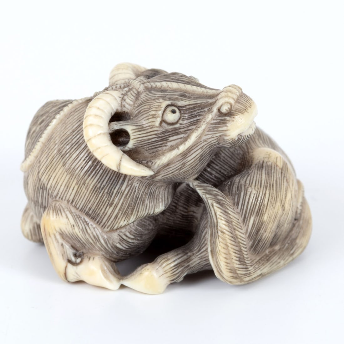 A Fine Carved Netsuke of a Recumbent Bull, Signed Tomokazu, Japan, (1 of 3)