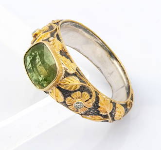 An 18K Yellow Gold and Sterling Silver Green Sapphire and Diamond Ring: An 18K Yellow Gold and Sterling Silver Green Sapphire and Diamond Ring A sterling shank engraved scrolling flowers in gold and accented with tiny diamonds. The head set with an oval-cut green sapphire