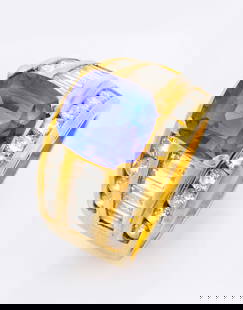 A Luxurious 18K Yellow Gold Tanzanite and Diamond Ring: A Luxurious 18K Yellow Gold Tanzanite and Diamond Ring The head set with a cushion-cut natural tanzanite (approx.?4.25?Ct), flanked by three gold channels set with 22 round brilliant-cut diamonds (app