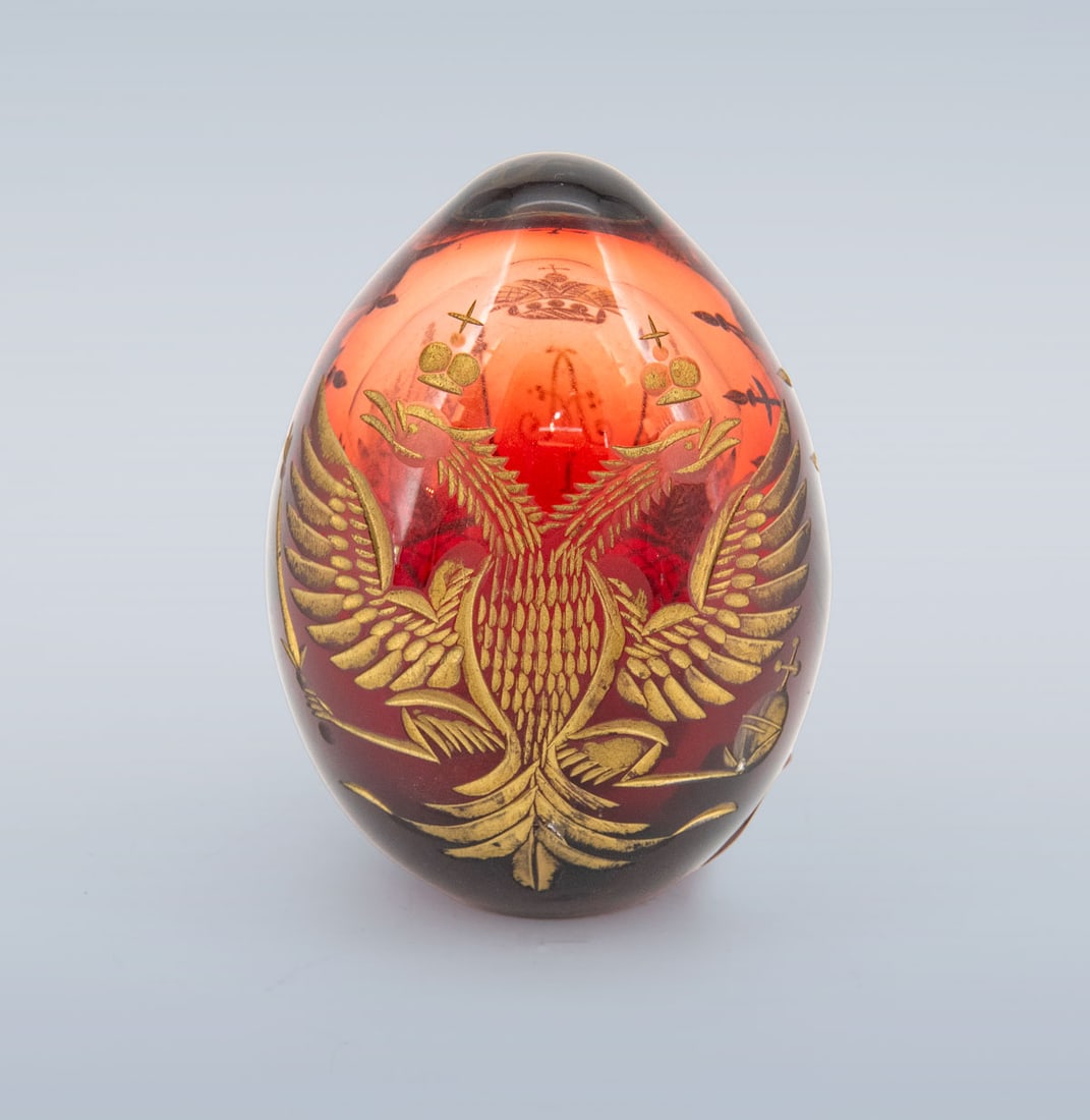 A Russian Red Blown Glass Paperweight,: A Russian Red Blown Glass Paperweight, Of heavy egg-shaped form, the translucent red glass finely decorated with gilt engravings depicting emblems of the Russian Imperial tradition. Height: 9 cm