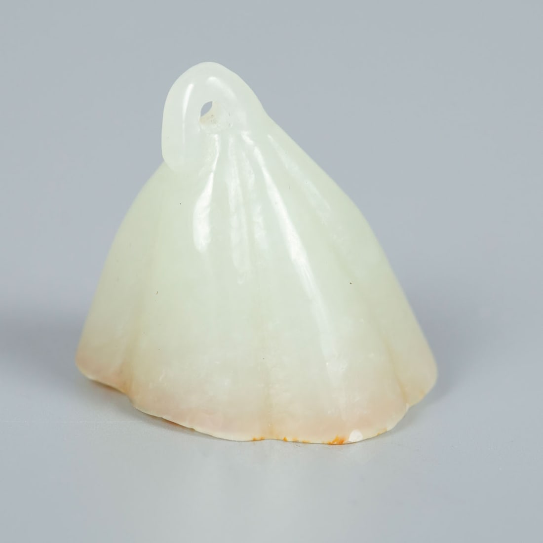 Celadon Jade Bell-Shaped Pendant, China, Qing Dynasty (1644-1912): Celadon Jade Bell-Shaped Pendant, China, Qing Dynasty (1644-1912) Bell-shaped pendant carved from celadon jade, the reverse with natural russet tone.Height: approx. 3 cm.Condition: For a full conditio