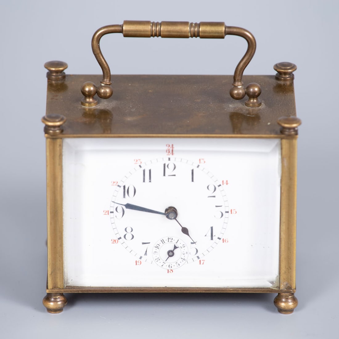 A Brass Carriage Clock, 19th Century: A Brass Carriage Clock, 19th Century Rectangular structure with clean lines terminating in geometric corner ornaments and raised on matching decorative feet. White enamel dial displaying Arabic numera