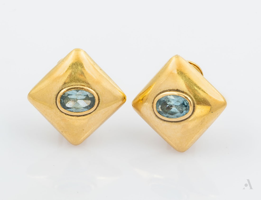 A Pair of 14K Yellow Gold and Blue Topaz Clip Earrings: A Pair of 14K Yellow Gold and Blue Topaz Clip Earrings Each centered by an oval-cut blue topaz, with clip-back fittings. Marked and gold acid tested. Length: approx. 16 mm; Total weight: 2.75 gr