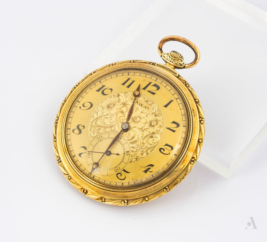 An Art Deco DOXA 14K Yellow Gold Pocket Watch, ca 1920s-1930s: An Art Deco DOXA 14K Yellow Gold Pocket Watch, ca 1920s-1930s Round case with a glass lidded front and the bezel engraved with foliage. Fitted with two back covers both made of gold. The dial in a gol