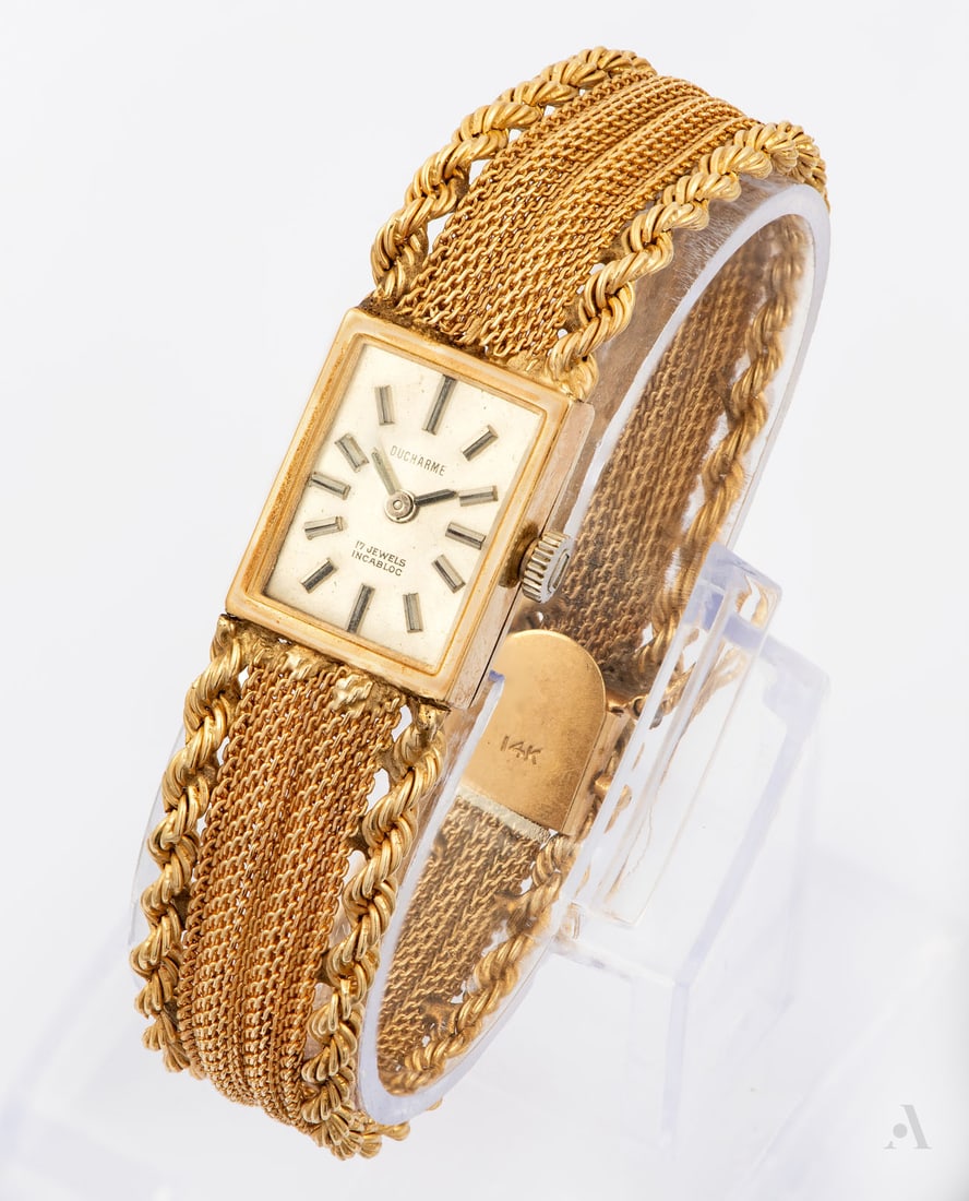 A Ducharme 14K Yellow Gold Ladies' Wristwatch, 1970s: A Ducharme 14K Yellow Gold Ladies' Wristwatch, 1970s Movement: Mechanical Case: Rectangular 14K yellow gold (hallmarked and acid tested) Dial: White with sweeping baton hands Band: A 14K yellow gold m