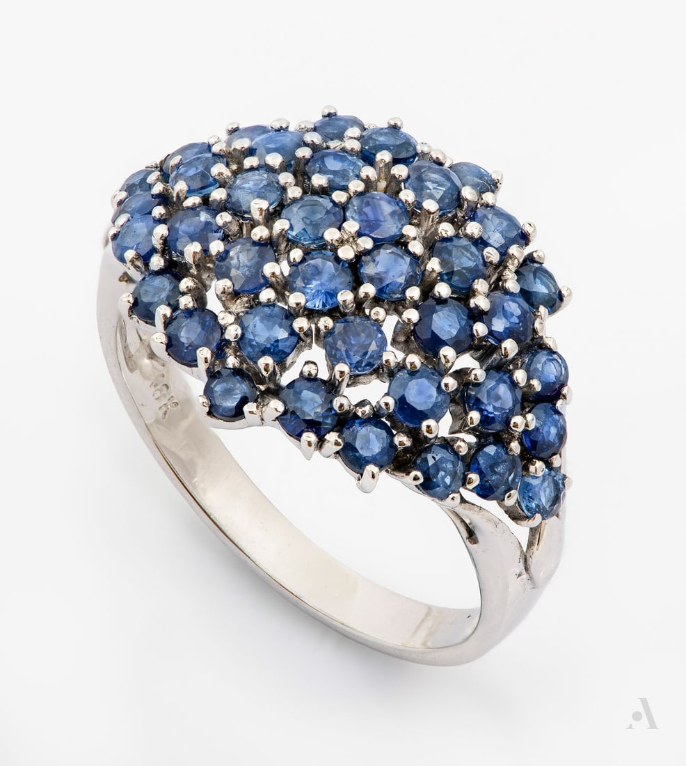A Fine 18K White Gold and Sapphire Cluster Ring: A Fine 18K White Gold and Sapphire Cluster Ring The head designed as a domed rhomboid, pave-set with briliant-cut sapphires and mounted on a rounded white gold band. Marked and gold acid tested.