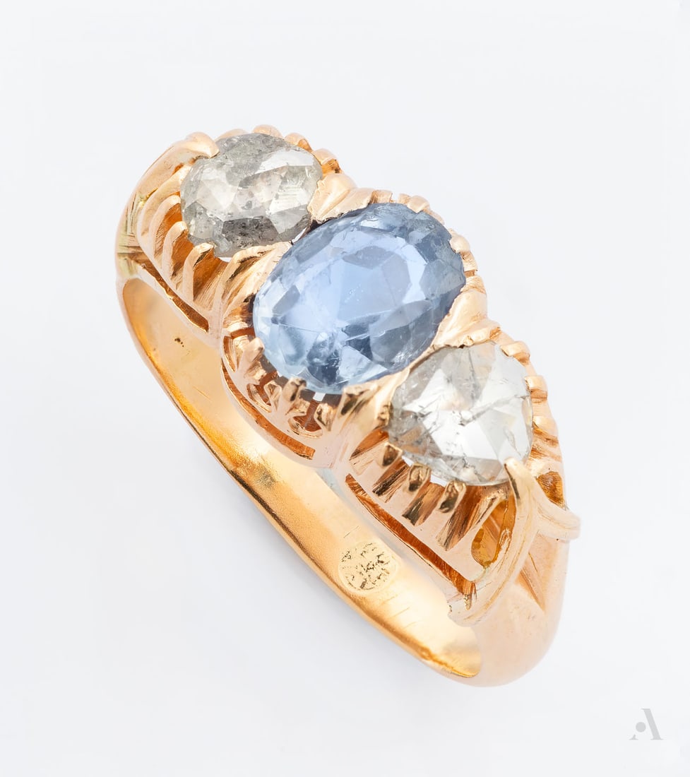 An Art Nouveau 14K Gold Sapphire and Diamond Ring: An Art Nouveau 14K Gold Sapphire and Diamond Ring The crown decorated with hand-pierced openwork, set with a central oval-cut light blue sapphire (approx. 1 Ct), flanked on both sides by diamonds (app