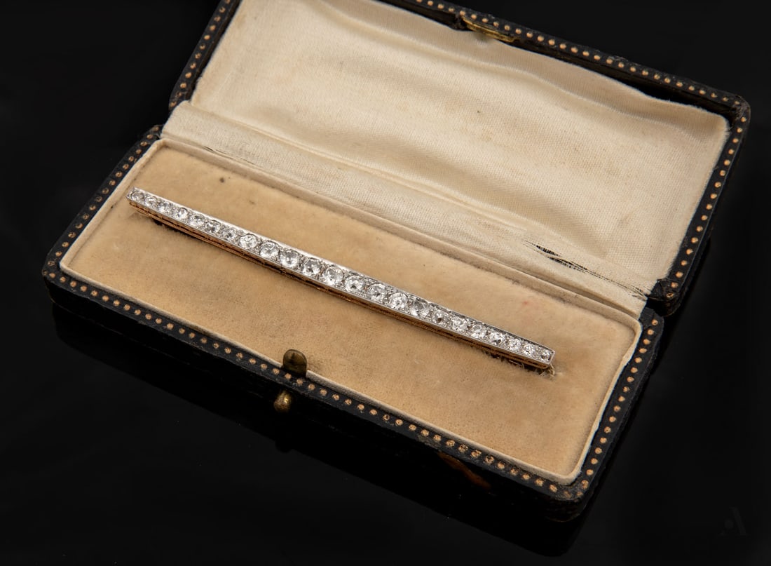 An Art Deco Gold Platinum and Diamond Bar Brooch: An Art Deco Gold Platinum and Diamond Bar Brooch Set with 23 old-cut diamonds (approx. 1.7 Ct in total), the top section in platinum, the reverse in 14K gold, and the pin in 9K gold. Including an orig