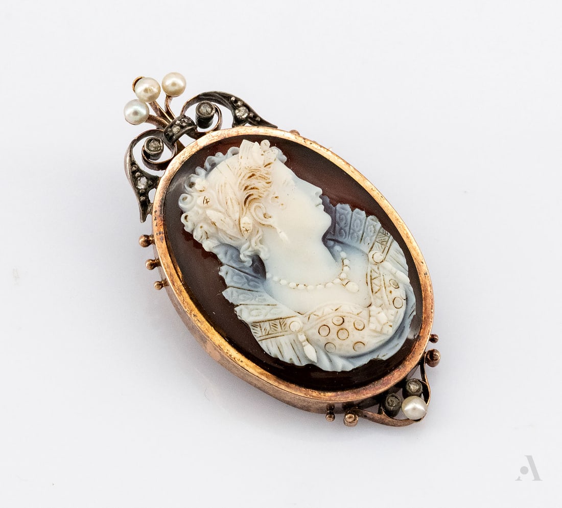 An 18K Rose Gold Pearl and Diamond Cameo Brooch, France, 1860-1880: An 18K Rose Gold Pearl and Diamond Cameo Brooch, France, 1860-1880 Oval form with a high-quality hand-carved cameo depicting a typical Victorian female profile on layered agate. Mounted on a rose gold