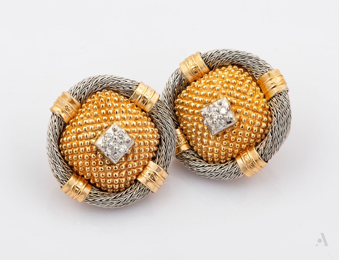 A Pair of 14K Two Tone Gold and Diamond Clip Earrings: A Pair of 14K Two Tone Gold and Diamond Clip Earrings A circular ear clips featuring a textured domed center in yellow gold, enclosed within a white gold twisted wirework border. The centers accented 