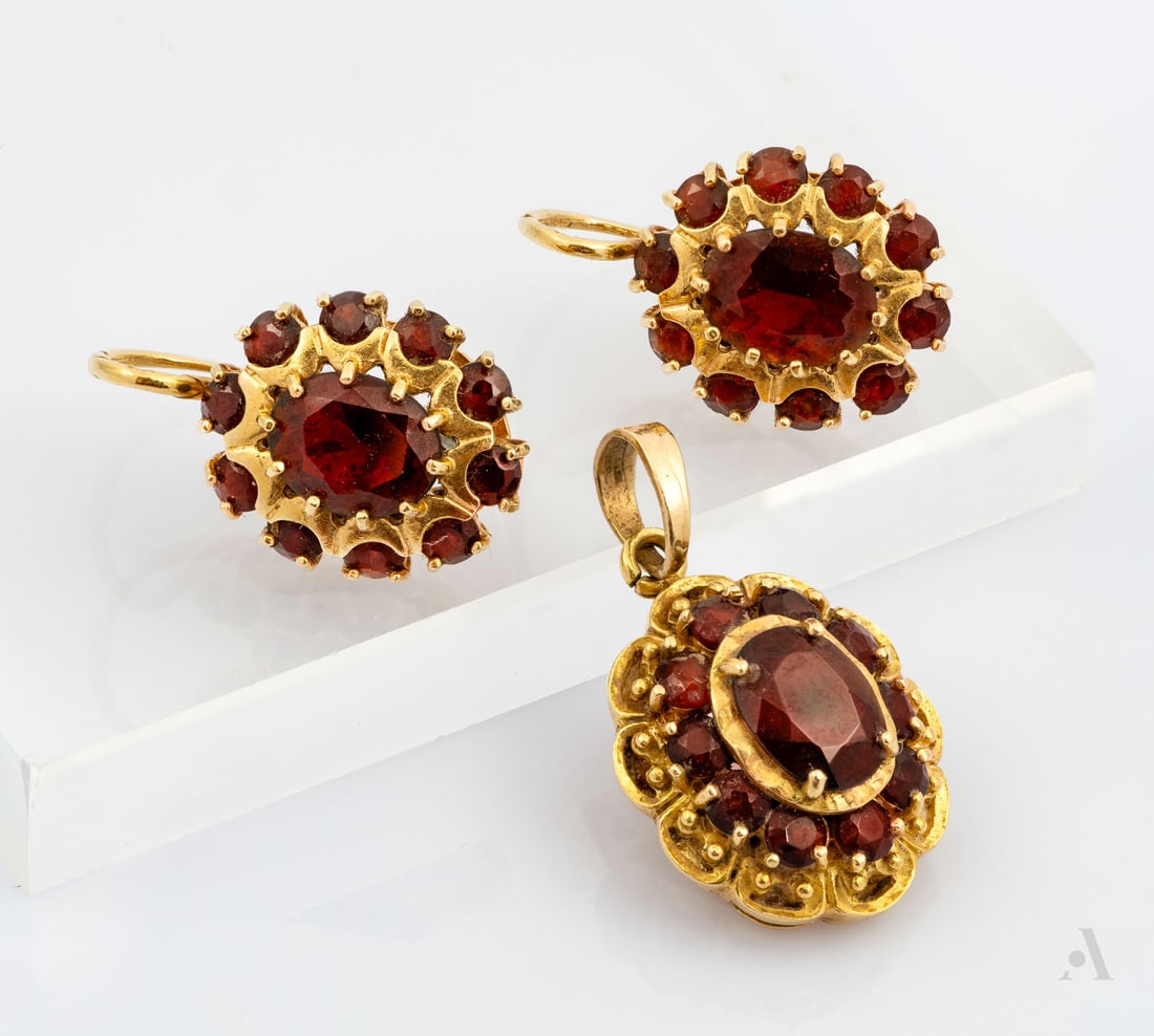 An 18K Yellow Gold and Garnet Pendant and Earrings Set: An 18K Yellow Gold and Garnet Pendant and Earrings Set All in a floral design and set with garnets. The pendant bail has been replaced and is crafted in 14K yellow gold. Marked and gold acid tested. T