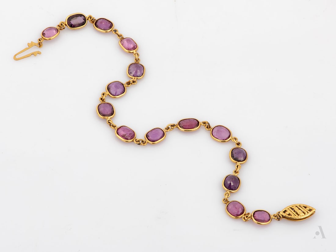 A 14K Yellow Gold and 12 ct unheated Ruby Tennis Bracelet: A 14K Yellow Gold and 12 ct unheated Ruby Tennis Bracelet Designed as a row 16 oval cut rubies (approx. 12 Ct in total) set in gold frames and connected between them by gold links. Marked a