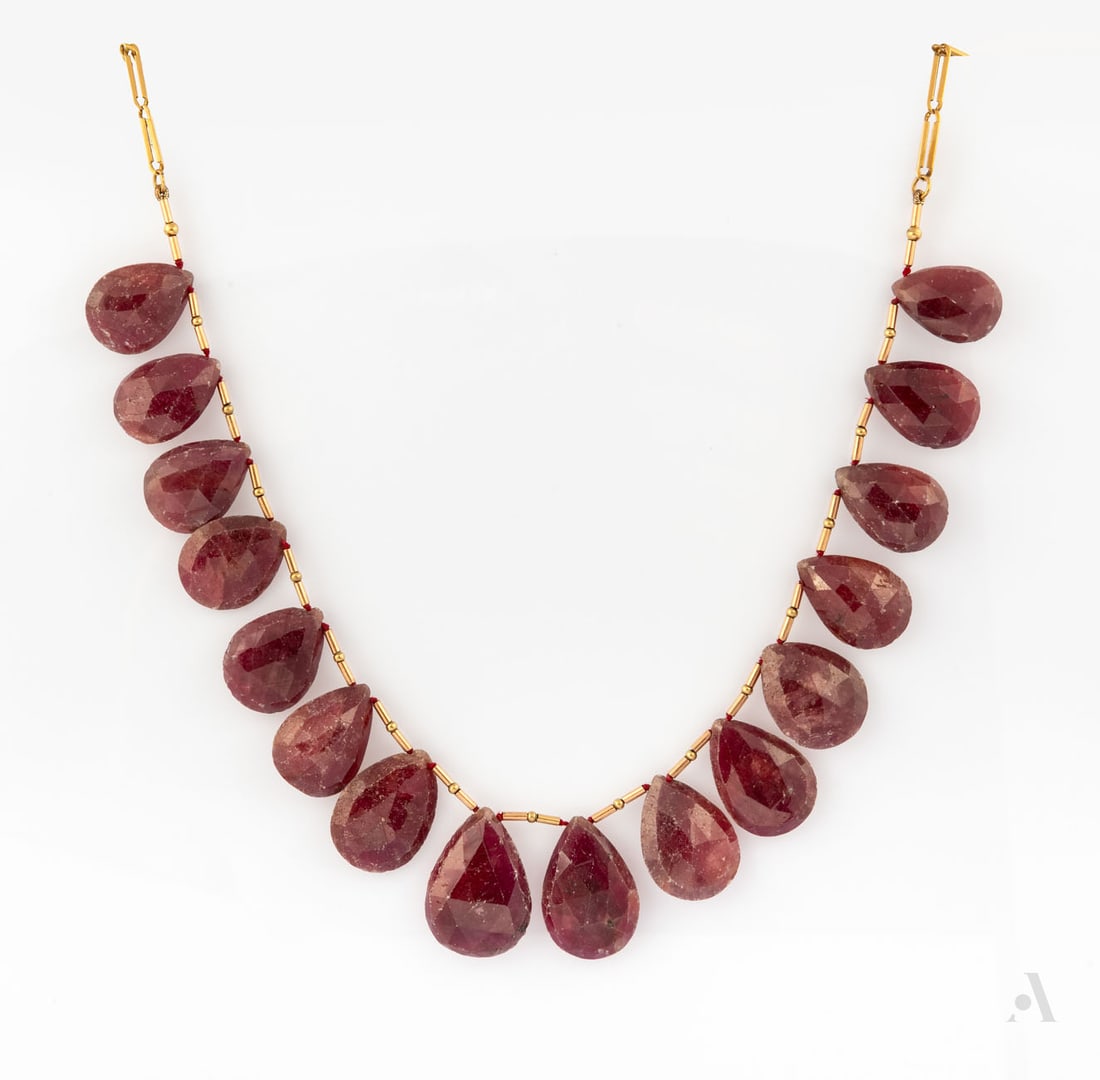 A 14K Yellow Gold and Gilt Metal and Ruby Necklace: A 14K Yellow Gold and Gilt Metal and Ruby Necklace Designed as a row of pear-cut rubies (approx. 250 Ct in total) in between tubular beads and gilt elements. Gilt clasp. Gold acid tested. Length: