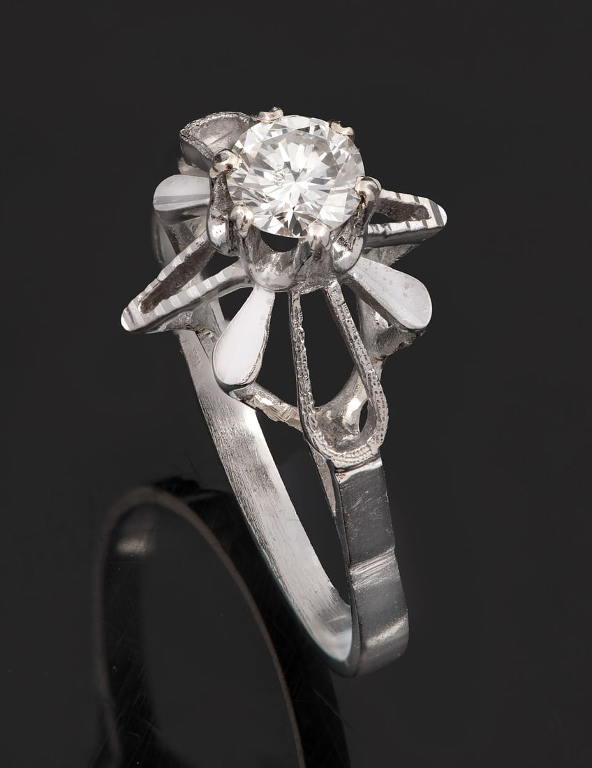 A 14K White Gold and Diamond Ring: A 14K White Gold and Diamond Ring Designed as a flower and centered by a brilliant-cut diamond (approx. 0.2 Ct). Marked and gold acid tested. Total weight: 2.4 gr; ring size: 7.5 Condition: For