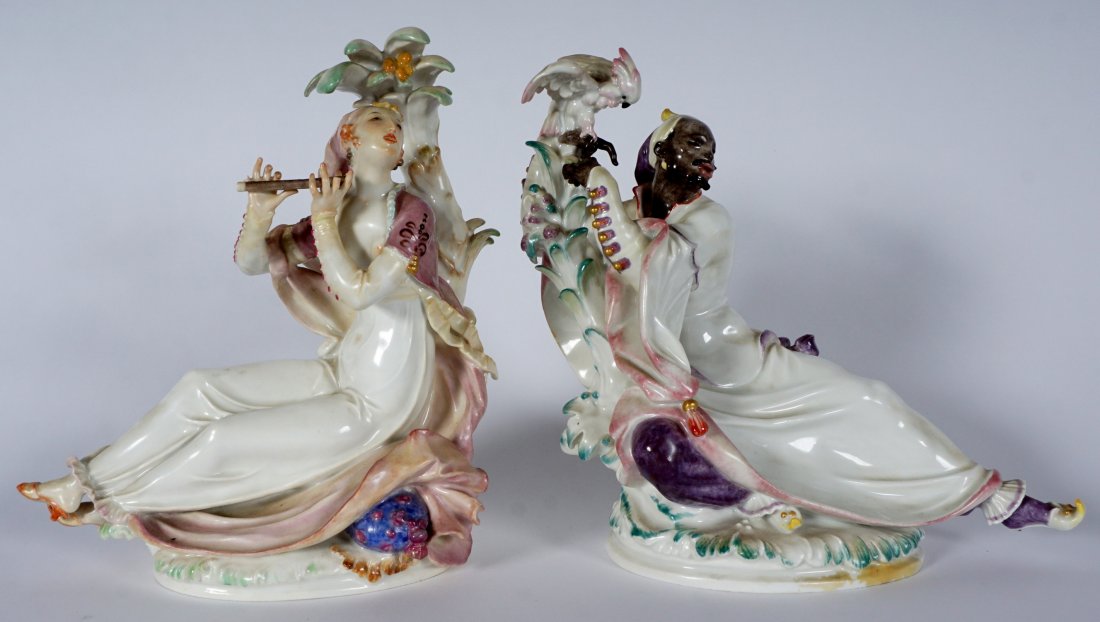 Pair Meissen Blackamoor and Woman Figural Groups: PAIR MEISSEN BLACKAMOOR AND WOMAN FIGURAL GROUPS: 2 piece Meissen porcelain figures to include 1) Reclining Blackamoor man with parrot on hand, foot outstretched, impressed A. 1068. 1490; blue crossed