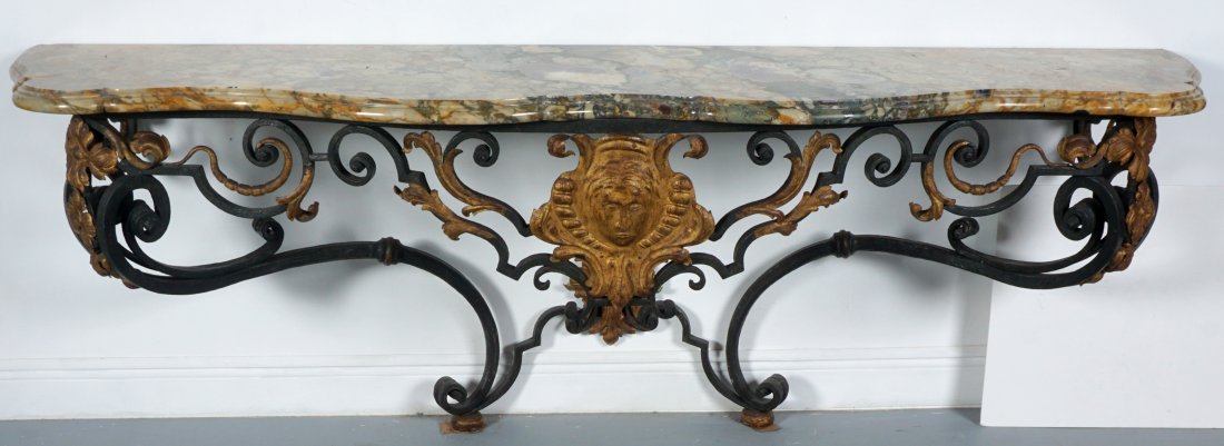 French Marble Top Wrought Iron Console Table: FRENCH MARBLE TOP WROUGHT IRON CONSOLE TABLE: 19th Century, serpentine marble top with copper, amethyst, and green coloration. Scroll work wrought iron base, gilt decorated masqueron and foliate accen