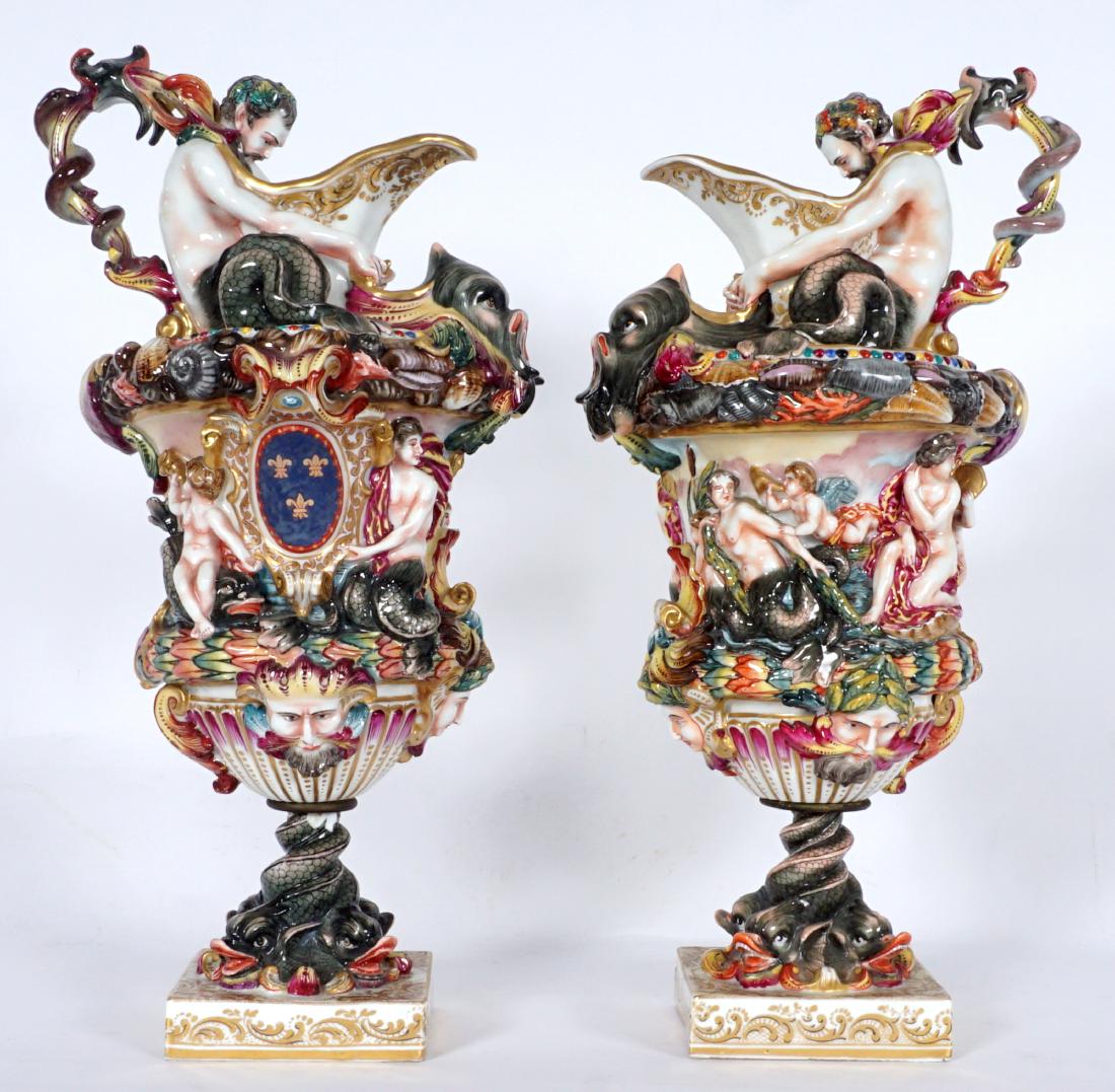 Pair Capodimonte Figural Porcelain Ewers: PAIR CAPODIMONTE FIGURAL PORCELAIN EWERS: Profusely decorated with high relief figural dolphin, merman, mermaids, masquerons and more. Blue Capodimonte crown over “N” mark, 17” h. x 9 ½”. Con