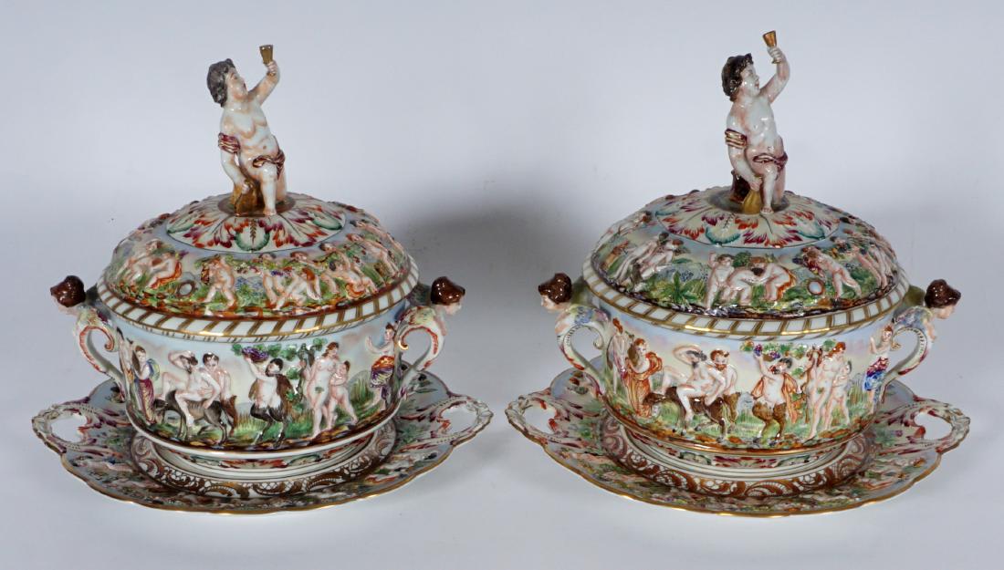 Pair Capodimonte Covered Tureens & Underplates: PAIR CAPODIMONTE COVERED TUREENS & UNDERPLATES: Lid, body, and underplate rim with relief Bacchanalian motifs, figural putti holding bottle and wine glass finial, winged maiden handles. Underplate wit