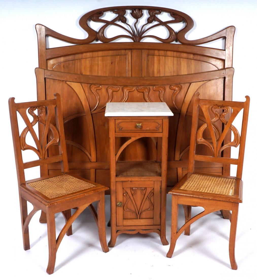French Art Nouveau Carved Walnut Bedroom Suite: Early 20th Century, 7 pieces total with carved and applied art nouveau accents to include 1) Full bed, headboard with openwork stylized water lilies, 59.25" h. x 54.5, footboard 43.5" h., rails 79". 2