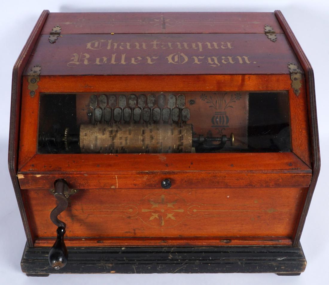 Chautauqua Concert Roller Organ With Cobs: Wood case with original stencil lettering and decals, lift top glass door, 20 key bellows. Sold with 38 cobs in varying condition, overall measures 12.25" x 18.25" x 15.25". Condition: Scratches and w