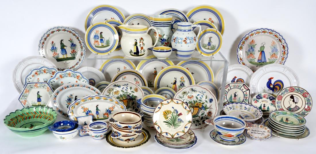 67 pice Quimper Faience Pottery Collection: An assembled collection of approx. 67 pieces Quimper pottery plates, bowls, pitchers, platters and more. Varying ages and designs. Condition: Multiple pieces with cracks and/or chips. Sold as-is.