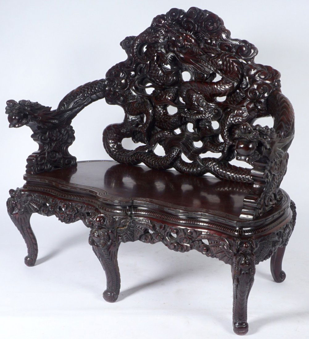Chinese Carved Dragon Settee: Circa late 19th to early 20th Century, open work carved back with smoke and figural dragon continuing to conforming arms. Serpentine carved skirt, figural winged creature legs, overall 47 1/2" h .x 51