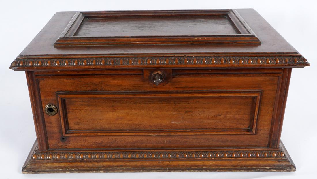 Walnut Music Disc Box with Spare Parts: Box with hinged lid, carved trim, applied molding. Inside of box is several spare parts for unknown disc player, case measures 10" h. x 22" x 16.5". Condition: Sold as parts only and as-is.