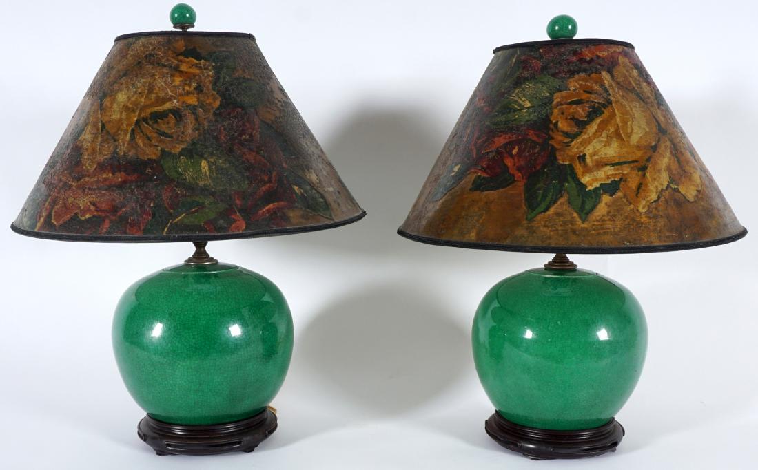 Pair Chinese Green Crackle Glaze Lamps: Squat bulbous porcelain body with green crackle glaze, wood base, matching green finial, single socket fixture. Overall 20" h. x .5". Condition: Crack to lid of one, glaze flaws to both.