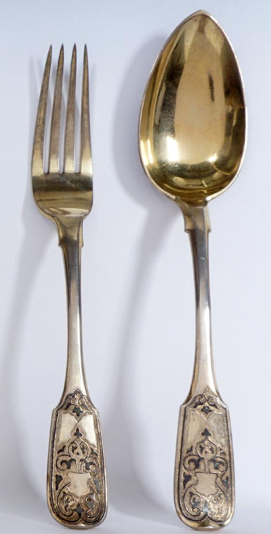 2pc Vasiliy Semenov Russian Silver Serving Set: Matching serving fork and spoon, engraved niello decoration, bearing a Cyrillic BC makers mark, 1875 assay mark, Moscow, traces of vermeil remain on on bowl and tines. Fork 8" long, spoon 8.5".