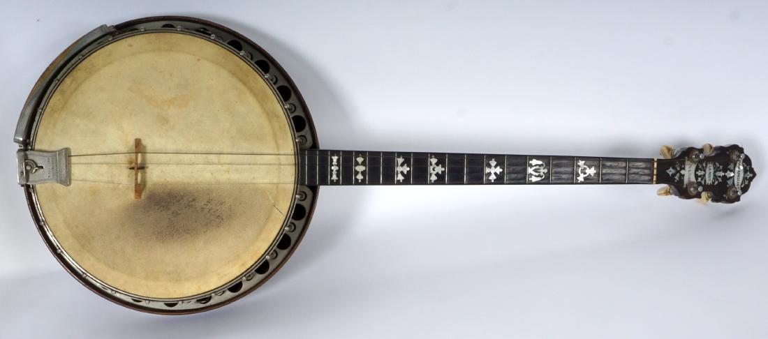 William Lange Paramount Leader Banjo: 4 string banjo by William Lange, mother of pearl inlaid fretboard. Rosewood resonator, overall 34.25" long x 13 1/2". Sold with original hard case. Condition: 1.25" tear to head, wear to MOP, other si