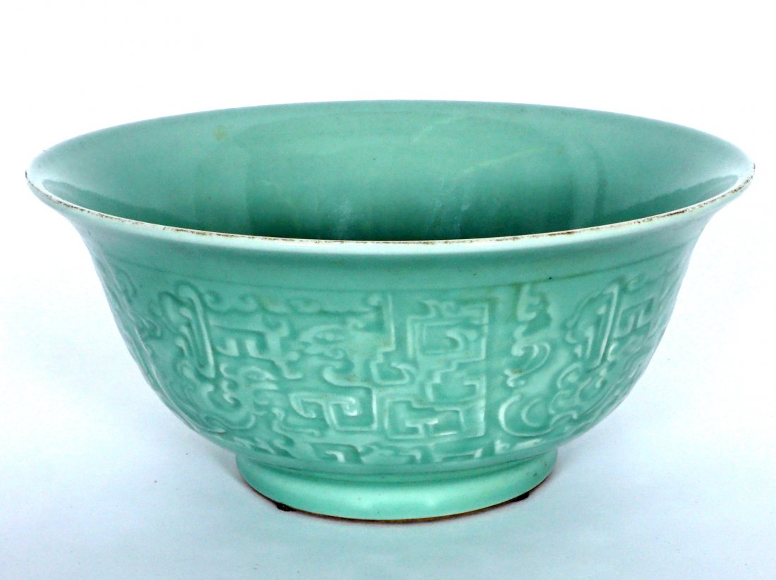 Chinese Celadon Bowl: Ming style, celadon glaze exterior raised carved with stylized animals and geometric design, raised foot, slightly flared rim, marked on base with 2 blue rings, no other markings, 5.5" h. x 12".
