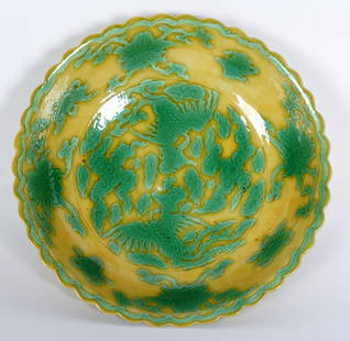 Chinese Kangxi Famille Verte Low Bowl: Low scalloped rim bowl, yellow ground, decorated with phoenix in clouds center, floral sides. Signed on footed base with blue underglaze Kangxi Qing Dynasty and double circle marks. 1" h .x 5.25"