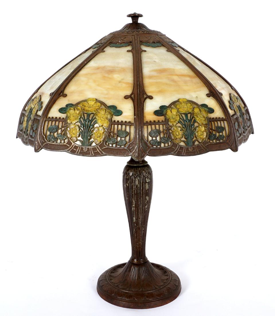 Nice A & R Slag Glass Table Lamp: Patinated metal base marked A & R Co., double socket fixture. 8 bent caramel slag glass shade, frame with paint decorated flowers in medallions. Base measures 23" h. x 7.25". Shade 8.5" x 17.75". Cond