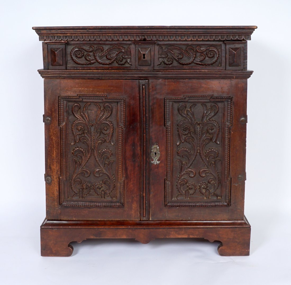 18th Century Italian Carved Credenza: Carved foliate motif single full length drawer over 2 doors. 8 interior drawers, prospect door opens to reveal additional 8 drawers, iron hardware. Measures 35.5" h. x 31.5" x 13". Condition: Evidence