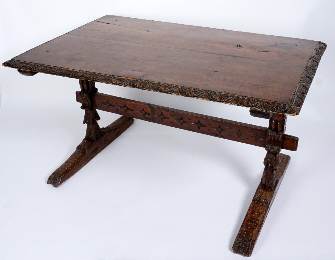 Early Italian Carved Walnut Refectory Table: Two board top, carved foliate trim, supports with carved figural putti, carved stretcher, splayed feet ending in carved figures. Overall 31" h. x 56.75" x 38". Condition: Several patch repairs, top is