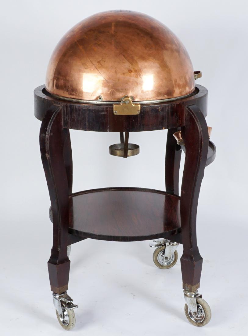 Rosewood and Copper Roast Beef Trolley: Edwardian roast beef or meat carving trolley, large globe dome form copper lid opens to spiked carving platform. Rosewood lower stretched shelf, on 4 large castors with rubber wheels. Articulated sauc