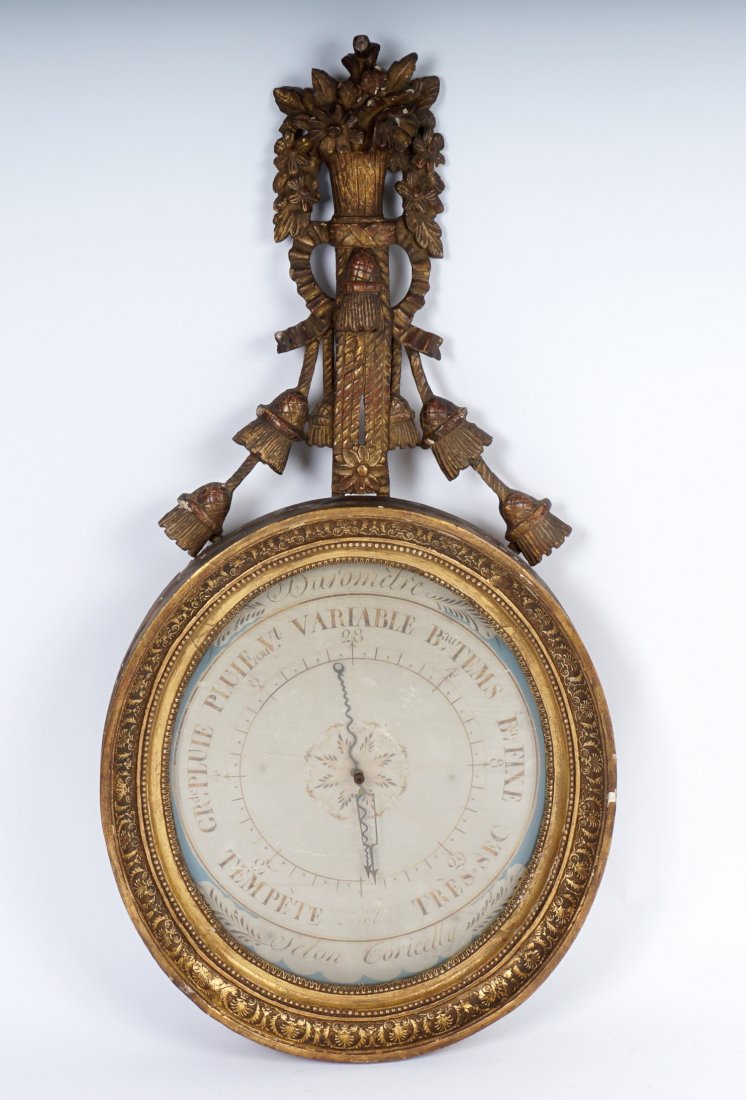 19th Century Selon Coricelly Carved Barometer: French carved gilt wood case, floral bouquet finial with rope tassels, oval carved bezel, paper dial with retailers name "Selon Coricelly", overall 37.25" h. x 18.75" x 3.5".
