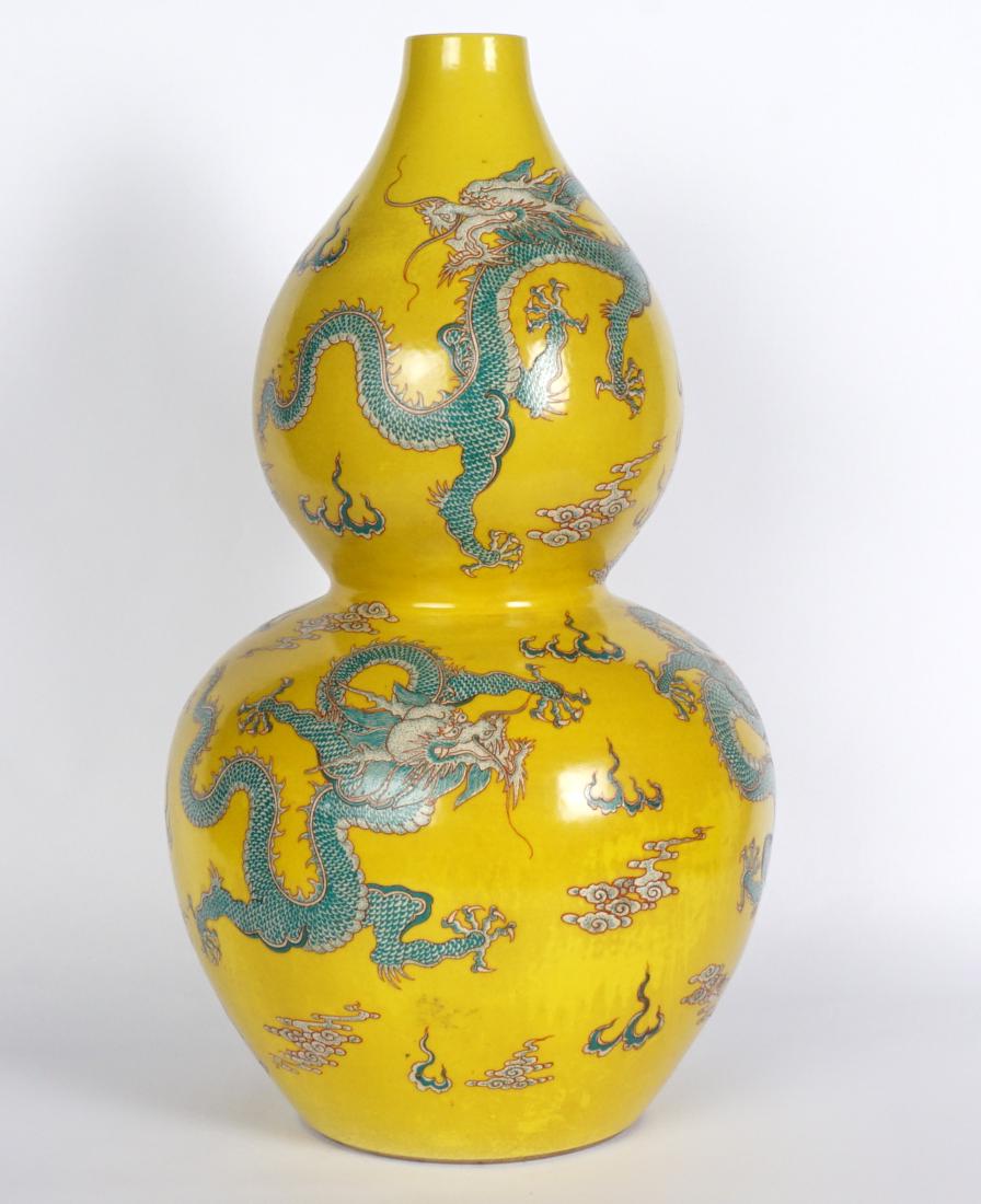 Chinese Famille Jaune Double Gourd Vase: Yellow ground with polychrome decorated dragons and whisps of smoke, bearing a spurious Kangxi mark. Overall 15.5" h. x 8.75".
