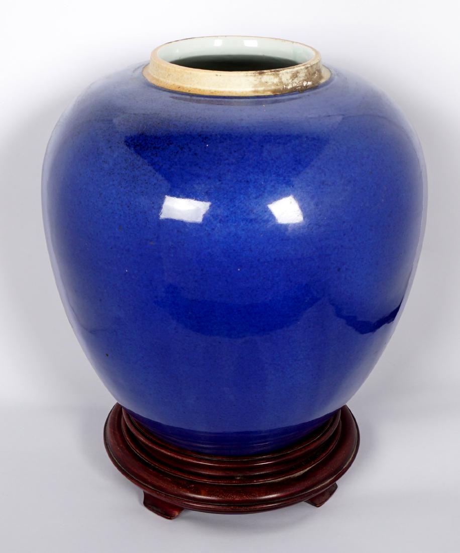 Chinese Qing Blue Glaze Porcelain Vase: Large ovoid form cobalt blue vase, possibly Kangxi Period (1662-1722), overall 9.5" h. x 9'" dia. Sold with wood stand. Condition: Glaze flaw near foot, Dark spots on top rim are old residue, not a re