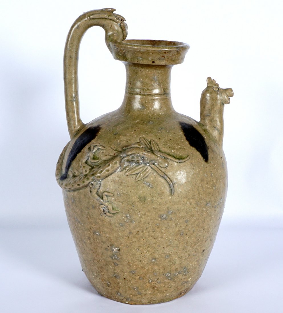 Chinese Six Dynasties Style Chicken Head Ewer: Earthenware ewer with chicken or cock head spout handle with stylized dragon head, body with relief figural dragon, iron marks on shoulder. Overall 10" h. x 6". Condition: Base chips, no repairs noted