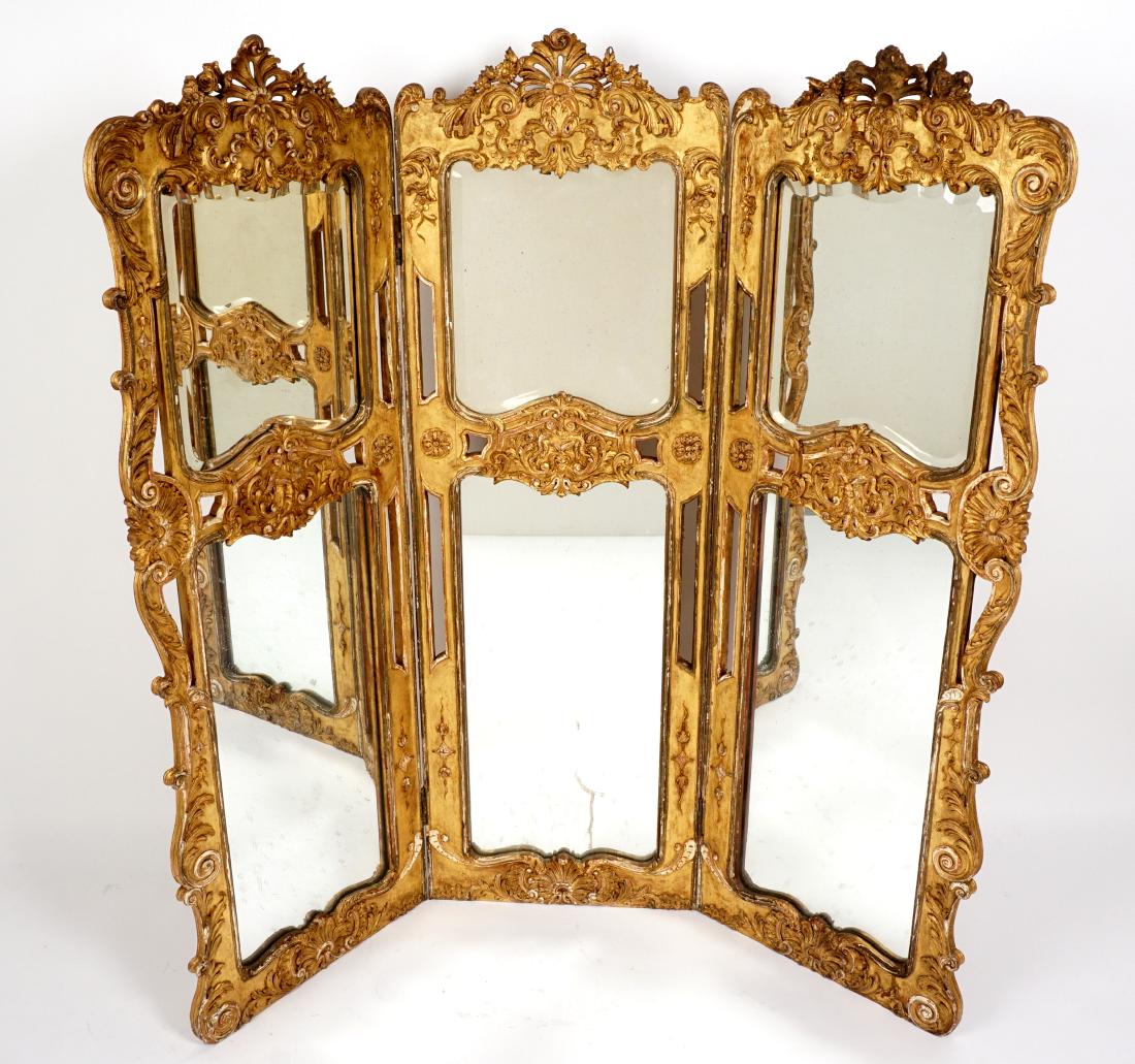 3 Panel French Carved Gilt Wood Mirrored Screen: Three panel French dressing screen, each panel interior with foliate carved crests and sides, masquerons center panel, beveled glass mirror panels top, glass mirror panels below. Verso with embroidery