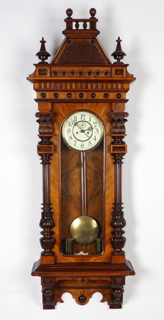 Mueller Schlenker German Vienna Regulator Clock: Removable architectural crest with spire and ball finials, applied "shingles", walnut veneer case, glass door with carved and fluted half columns, lower finials. Porcelain dial with Arabic numerals, s