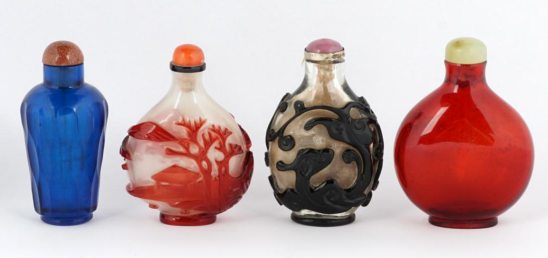 Four Peking Glass Snuff Bottles: Four bottles total to include 1) Translucent white ground, red overlay landscape, red stopper, 2.5" h. 2) Clear glass ground, black overlay figural Qilin, purple stop, 2.75". 3) Amber red glass, jade