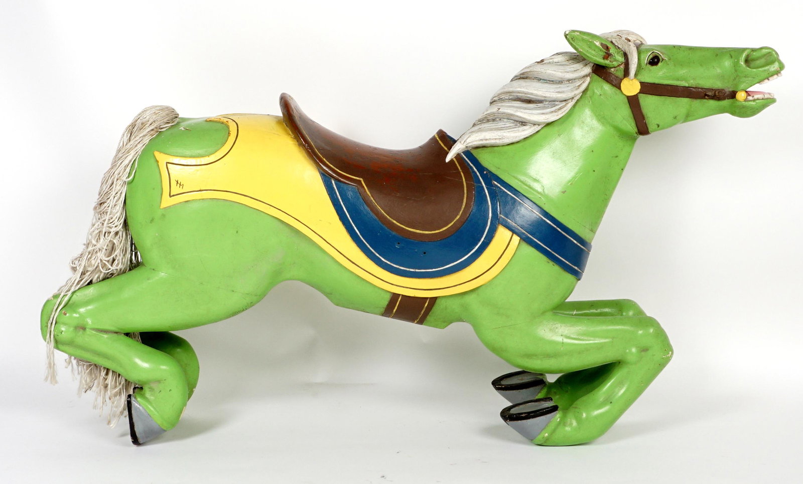 Victorian Carved Carousel Horse: Late 19th to early 20th Century carved carousel horse, green painted body, silver/white mane, brown saddle with yellow and blue accents. Most likely repainted at some time. Approx. 29.5" h. x 53" x 10
