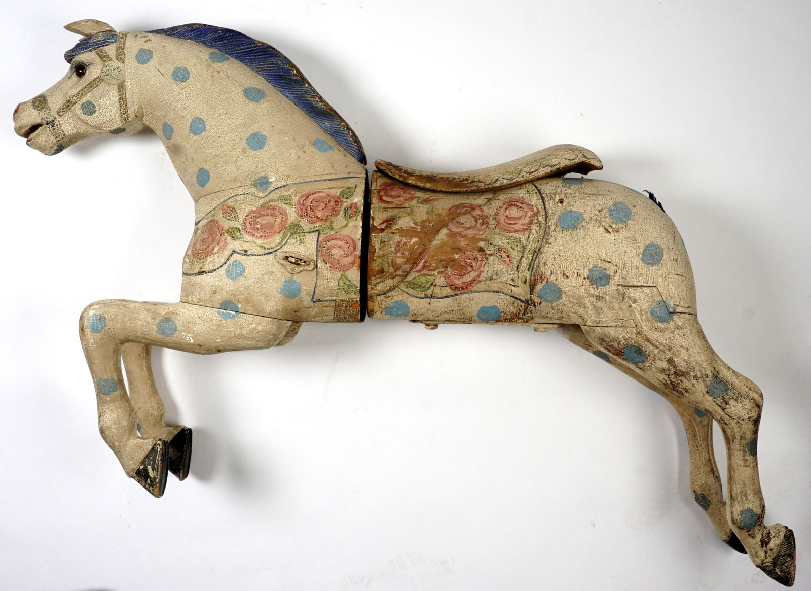 Vintage Polychrome Painted Carousel Horse: Early to mid 20th Century, in two pieces, white painted body with roses and blue polka dot accents, hollow body. Head piece measures approx. 35" h x 27" x 10.5", body approx. 34" x 32" x 10". Conditio
