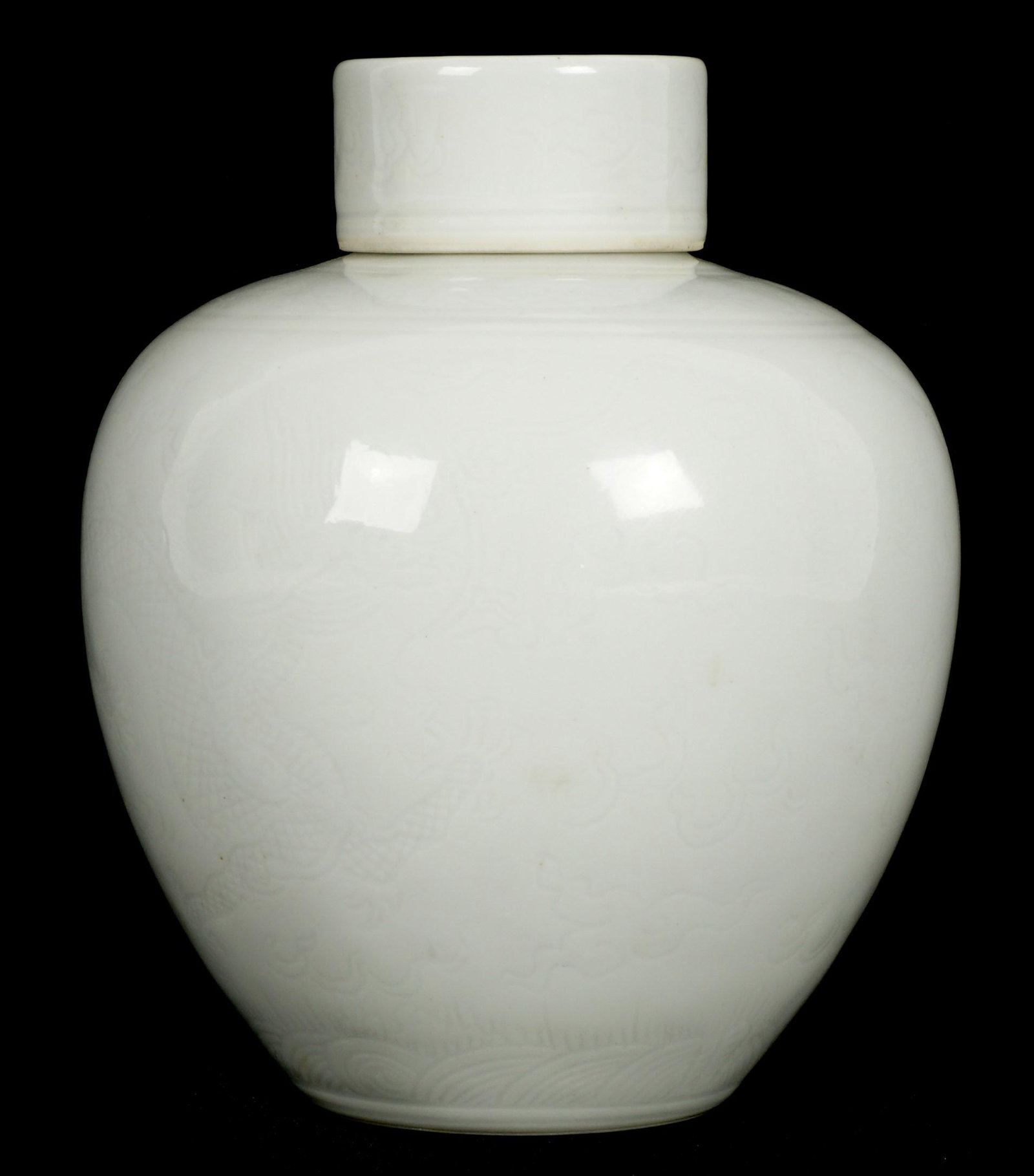 Qing Marked Chinese Incised Dragon Covered Jar: Squat ovoid jar, delicately incised with dragons in clouds over waves design, foliate ring on shoulder, incised lid, bearing a blue Jiaqing underglaze mark on base. 4.25" h. x 3.5".