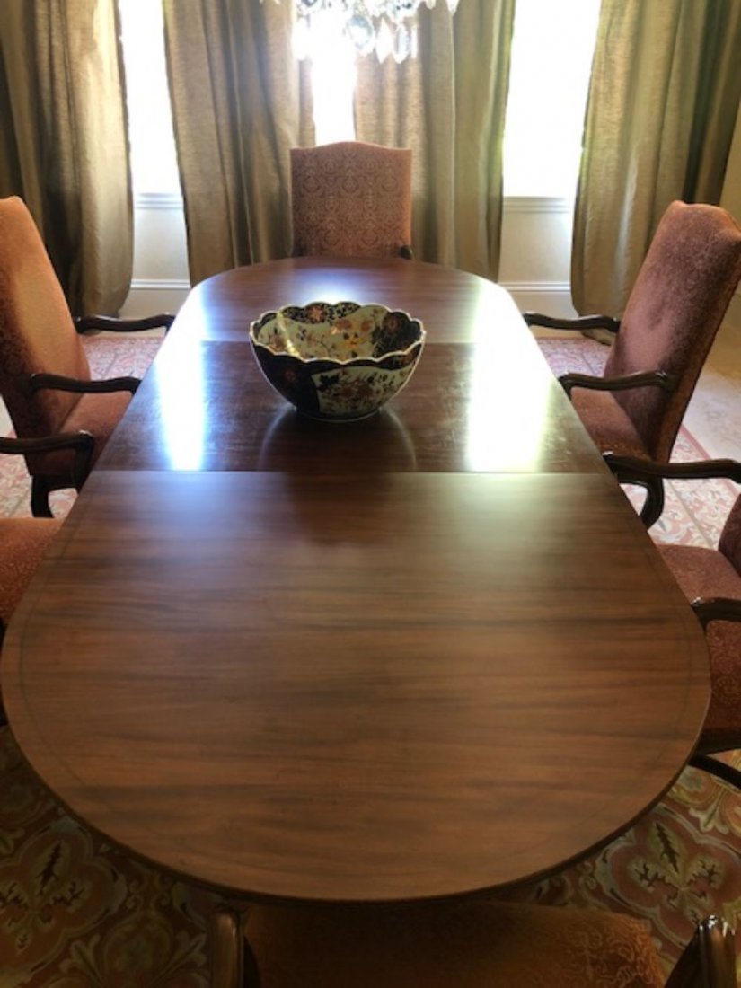 Sheraton Style Mahogany Triple Pedestal Table: 20th Century, double D end, mahogany top, inlaid band, reeded trim. Pedestal bases on 3 carved splayed legs ending in brass claw feet on castors. Overall 29.5" x 111.5" x 45.5", sold with two 16" leav